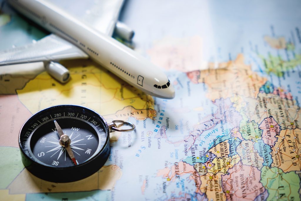 A plane and a compass on top of a travel map